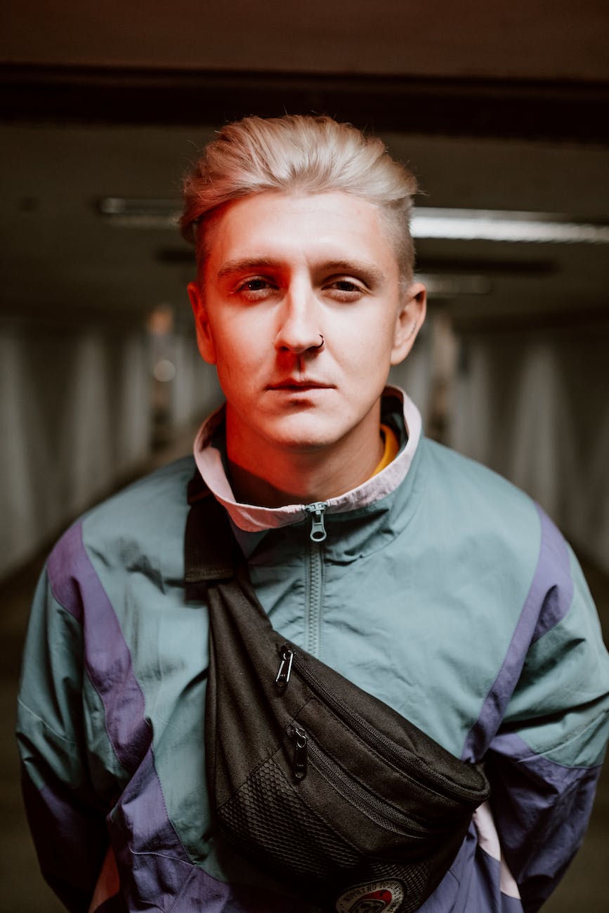 close up shot of a blond man wearing a black sling bag