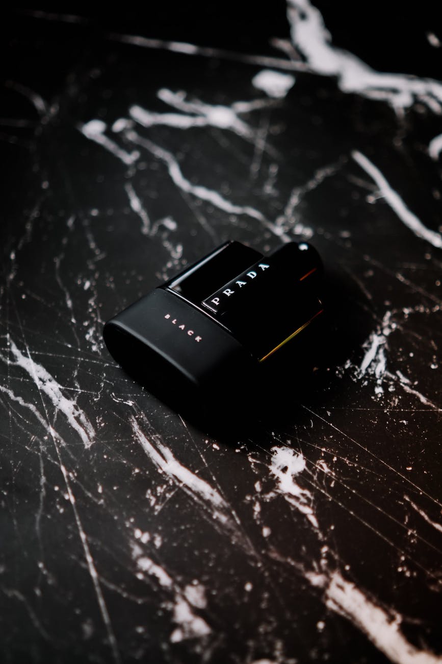 photo of a black perfume on a marble surface