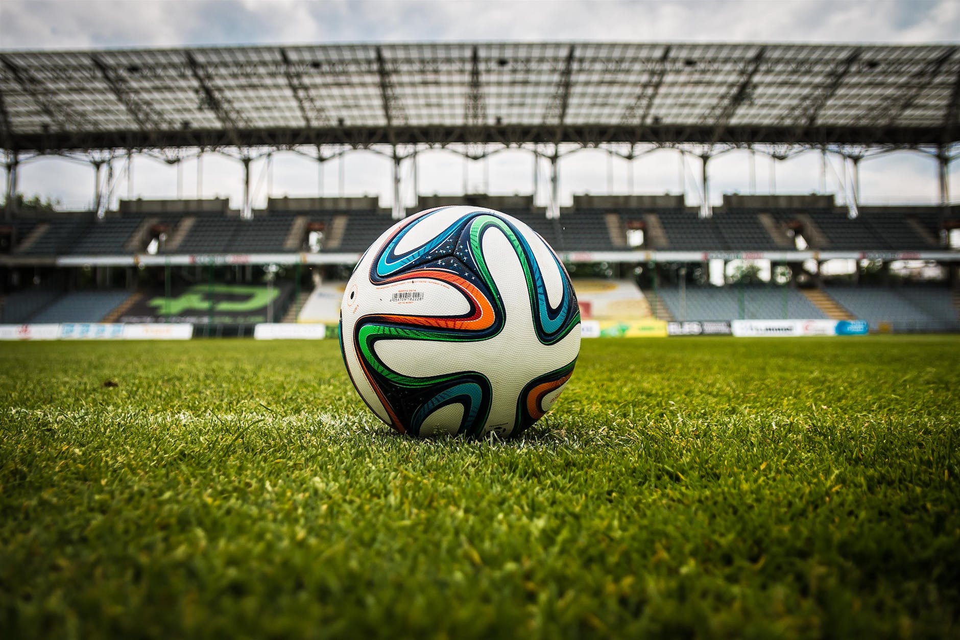 multicolored soccer ball on green field