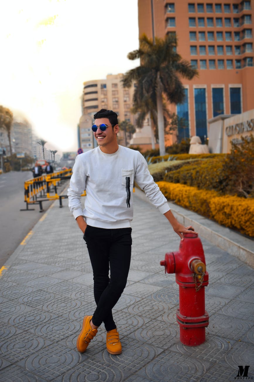 man in white long sleeved shirt holding red fire hydrant