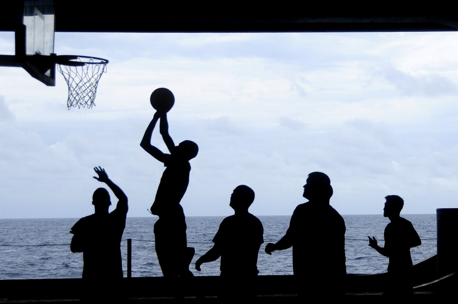 silhouette of men playing basketball