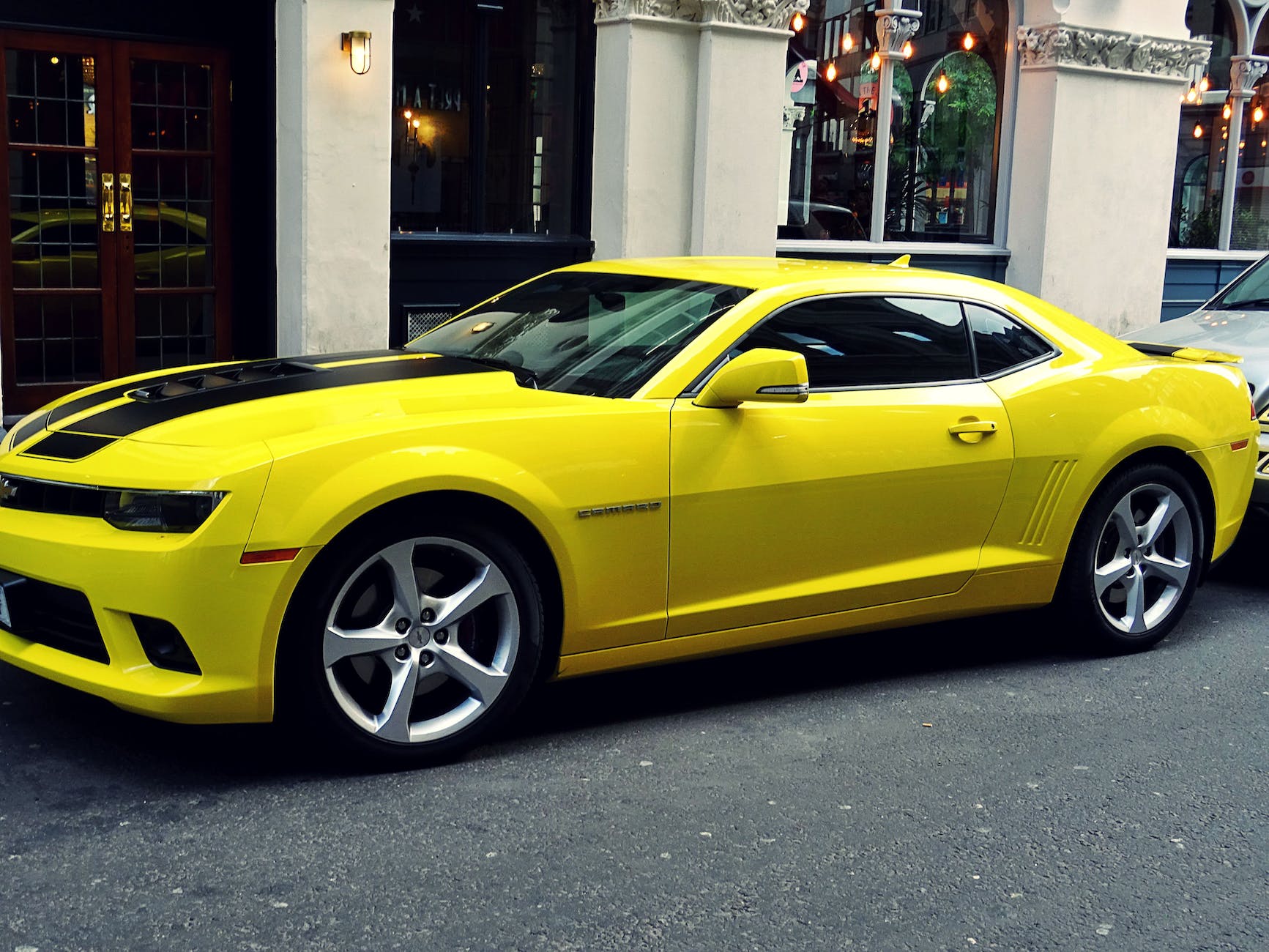 yellow chevroelt camaro parked outside of building