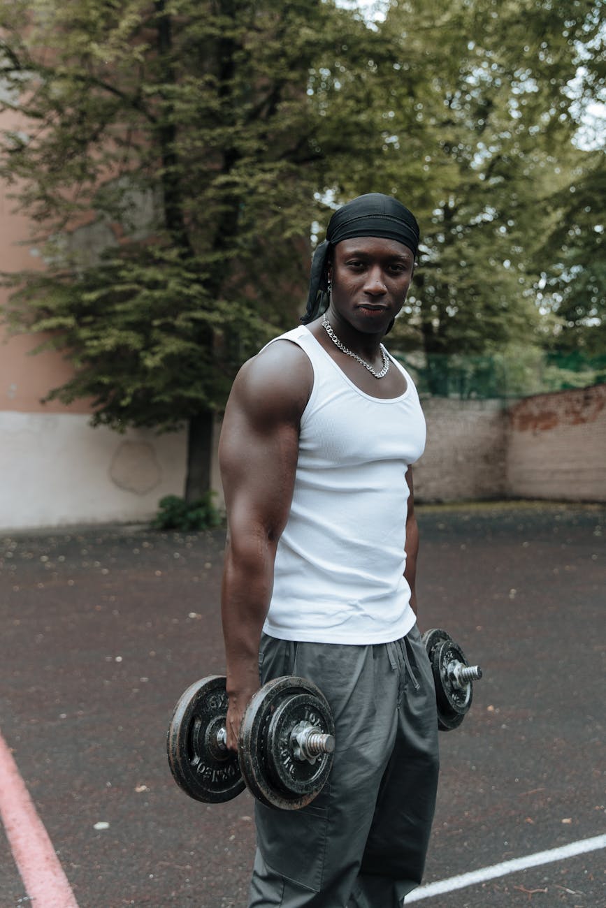 man in headband holding dumbbells