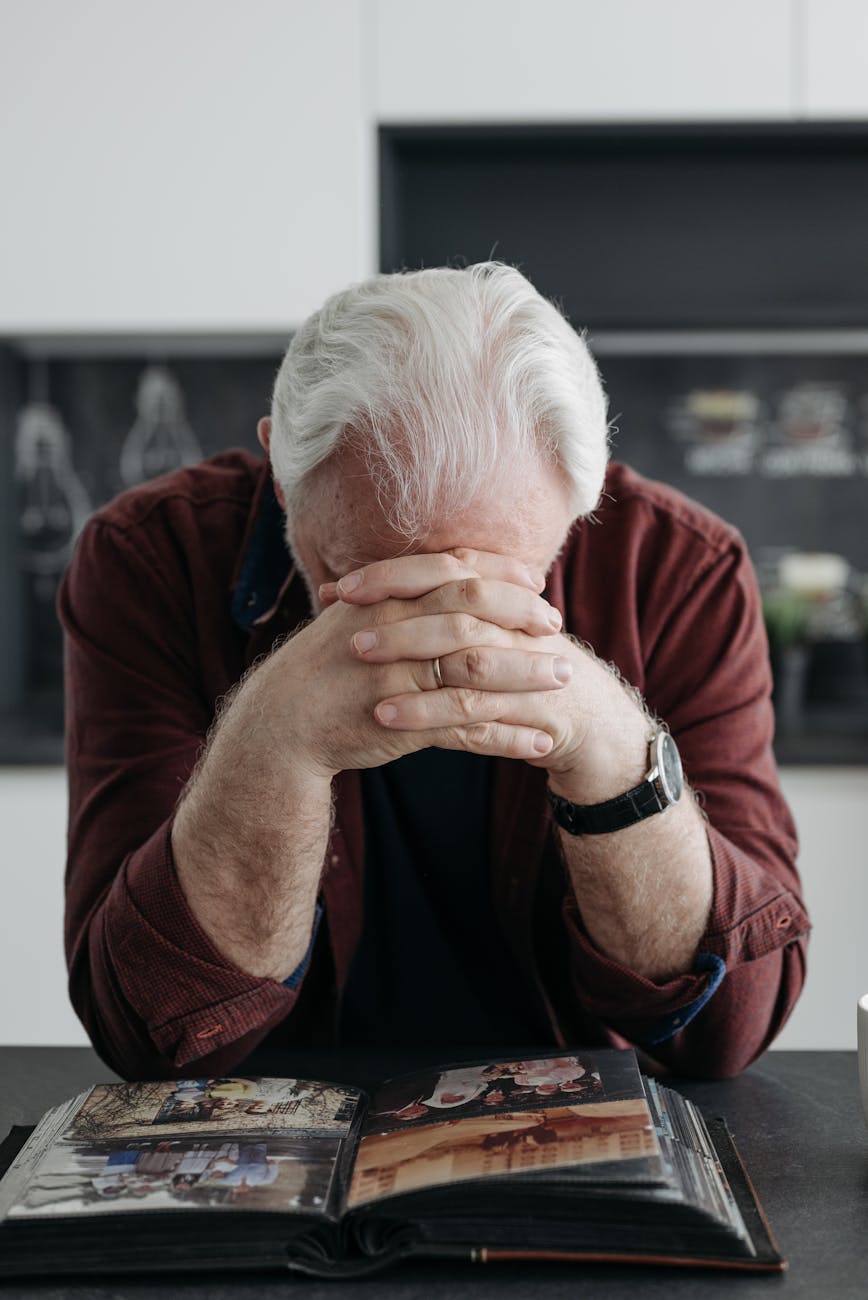 an elderly man looking at a photo album