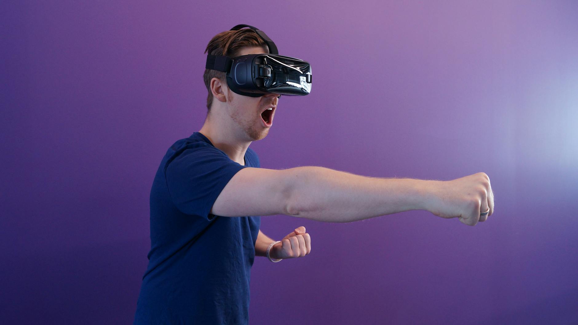 man punching in the air while in vr goggles