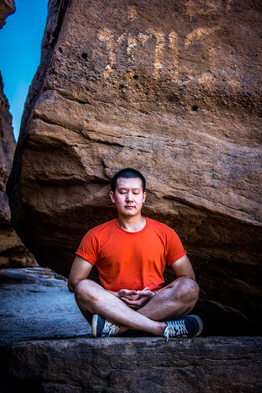 man meditating under rock